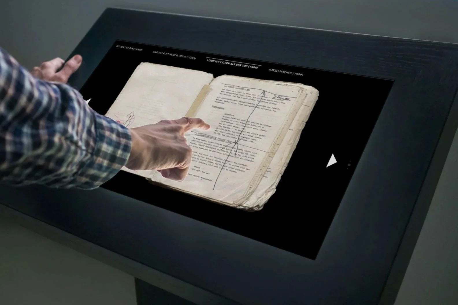 Touch-Tisch mit digitalisiertem Drehbuch, eine Hand blättert darin